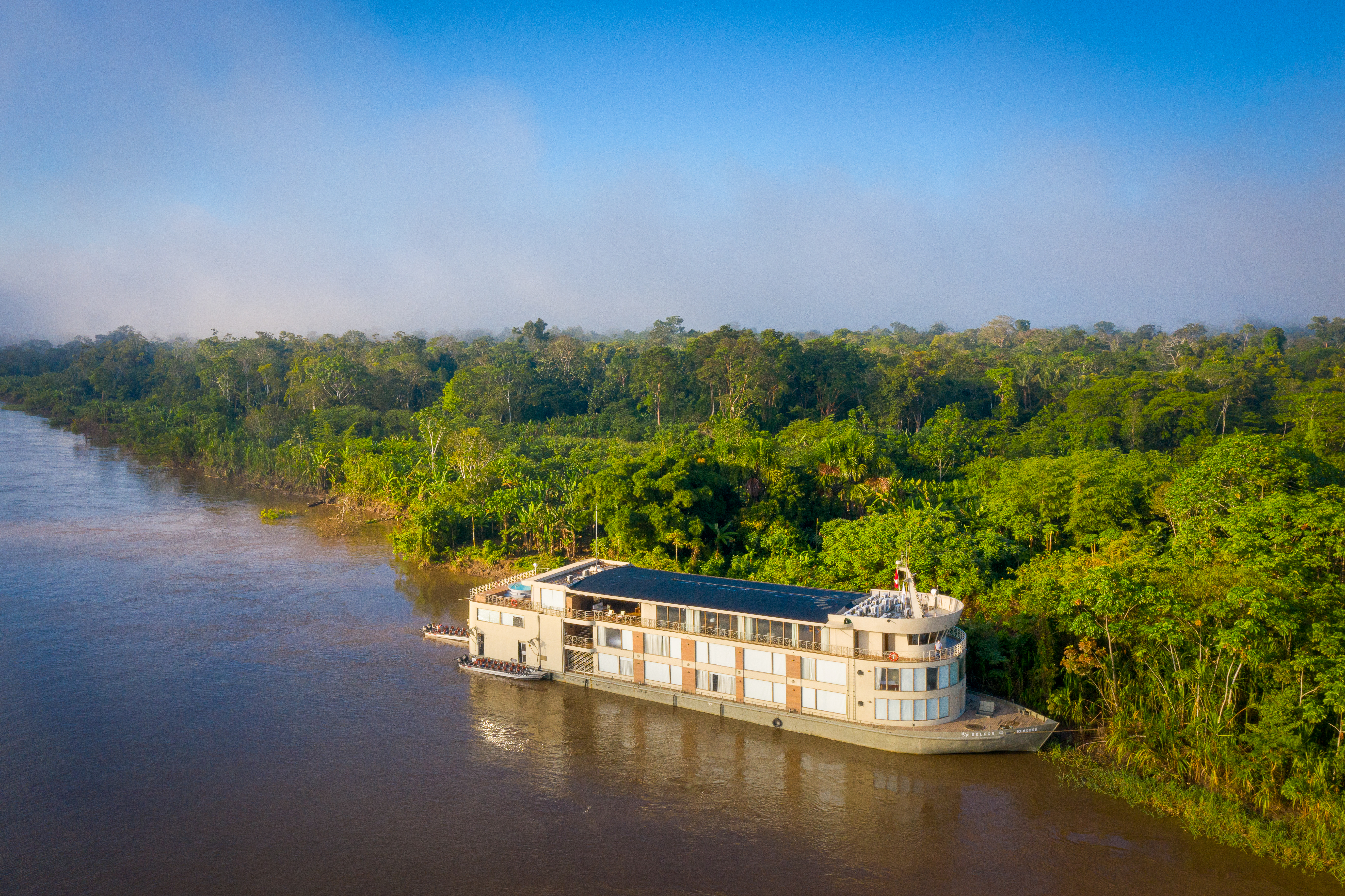 river cruise ship pulled up to the shore in a rainforest