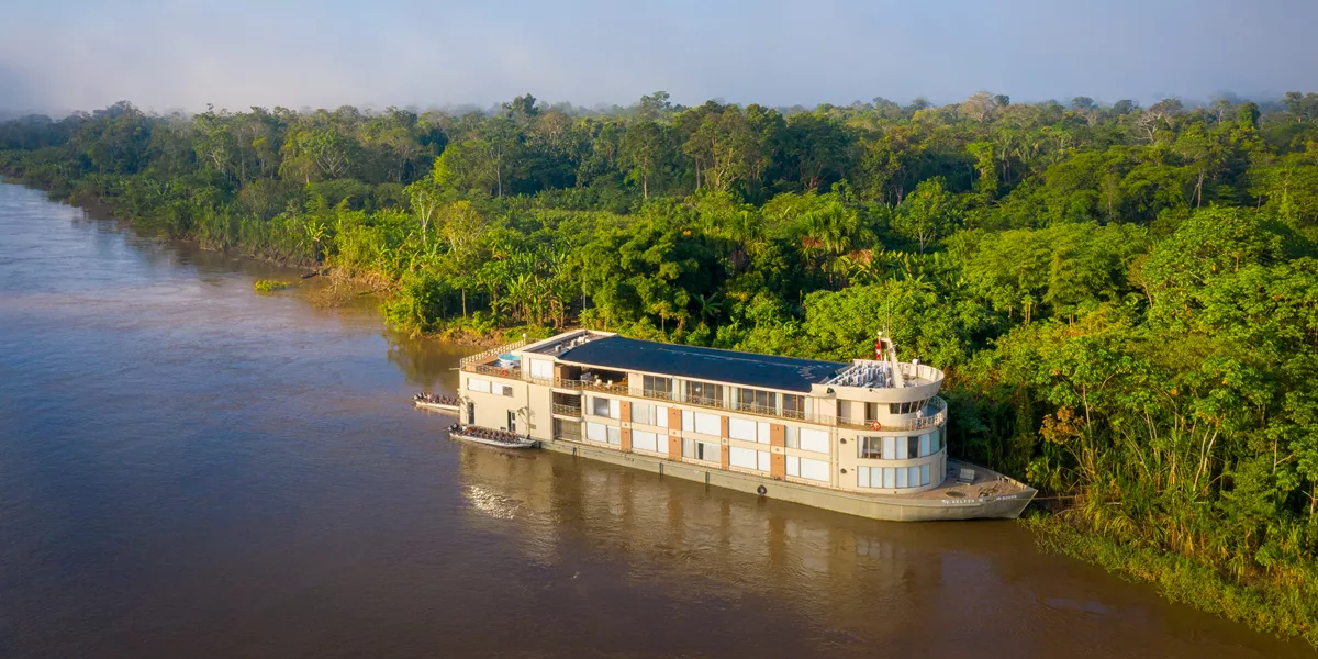 river cruise ship pulled up to the shore in a rainforest