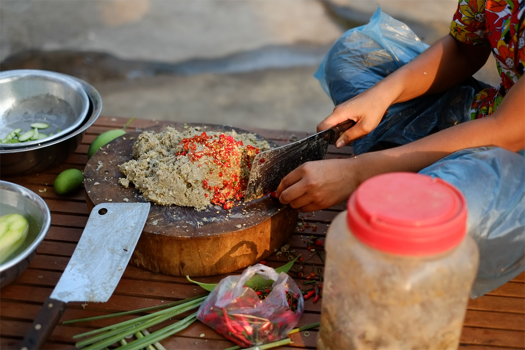person curring chilli and adding it to a paste