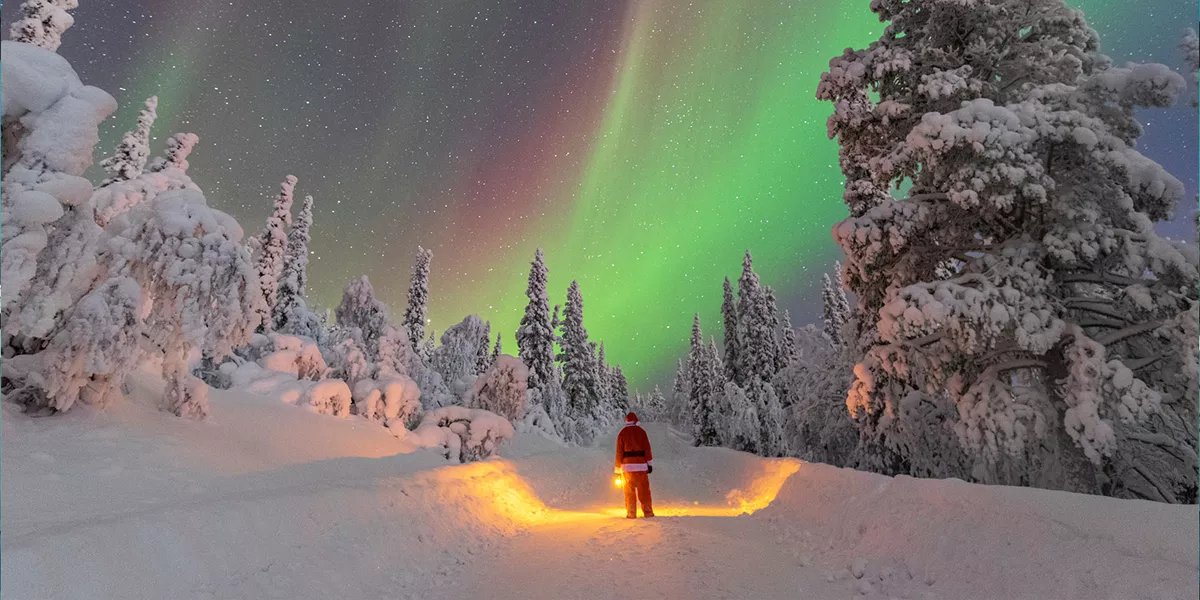 Person Dressed As Santa Looking At The Northern Lights