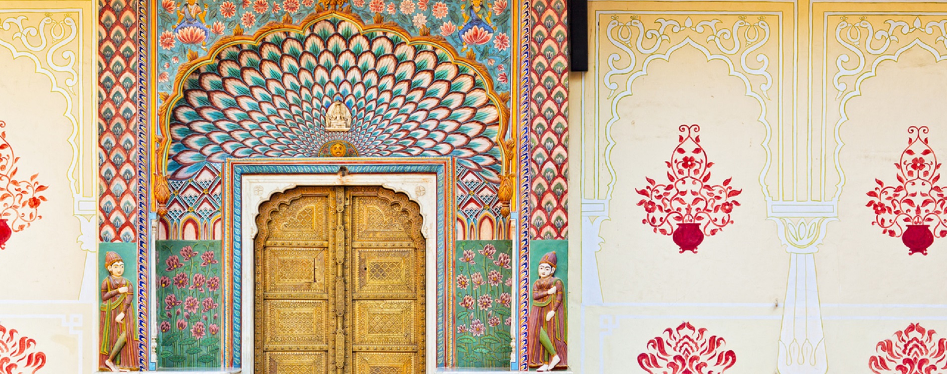 A large wooden door in front of a colorful wall