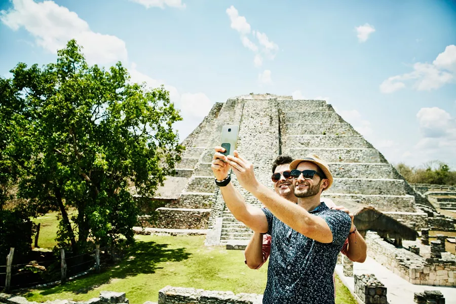 Smiling Couple Taking Selfie With Smartphone While Exploring Mayapan Ruins During Vacation