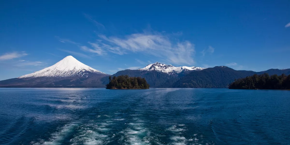 Looking out the back of a boat crossing a lake