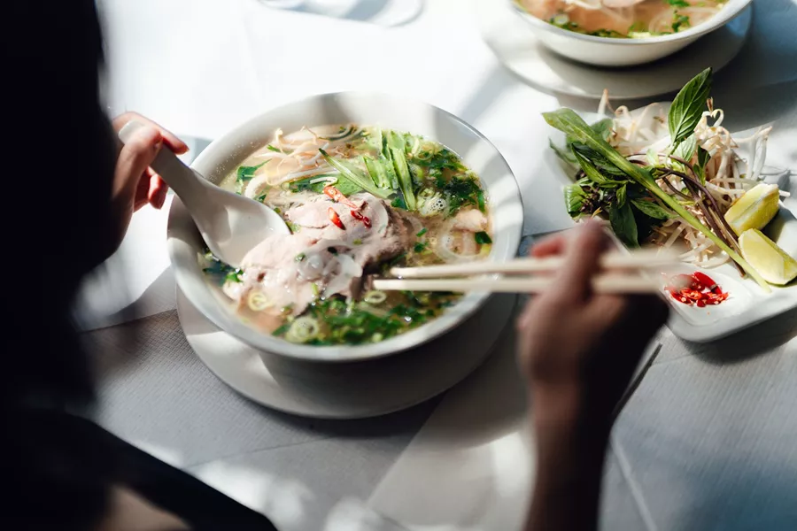 Woman Eating Vietnamese Pho Soup With Noodles And Beef