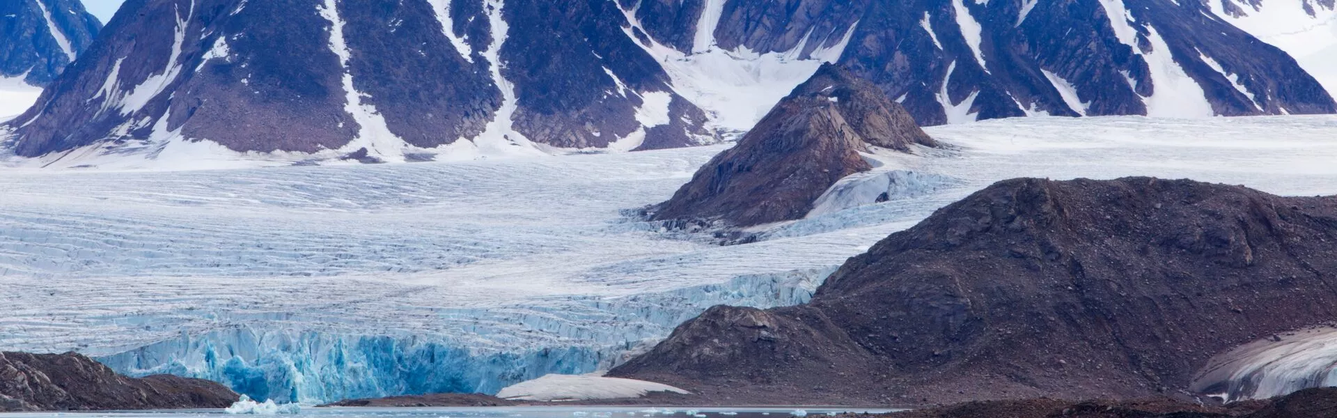 Mountains with a glacier flowing into the ocean