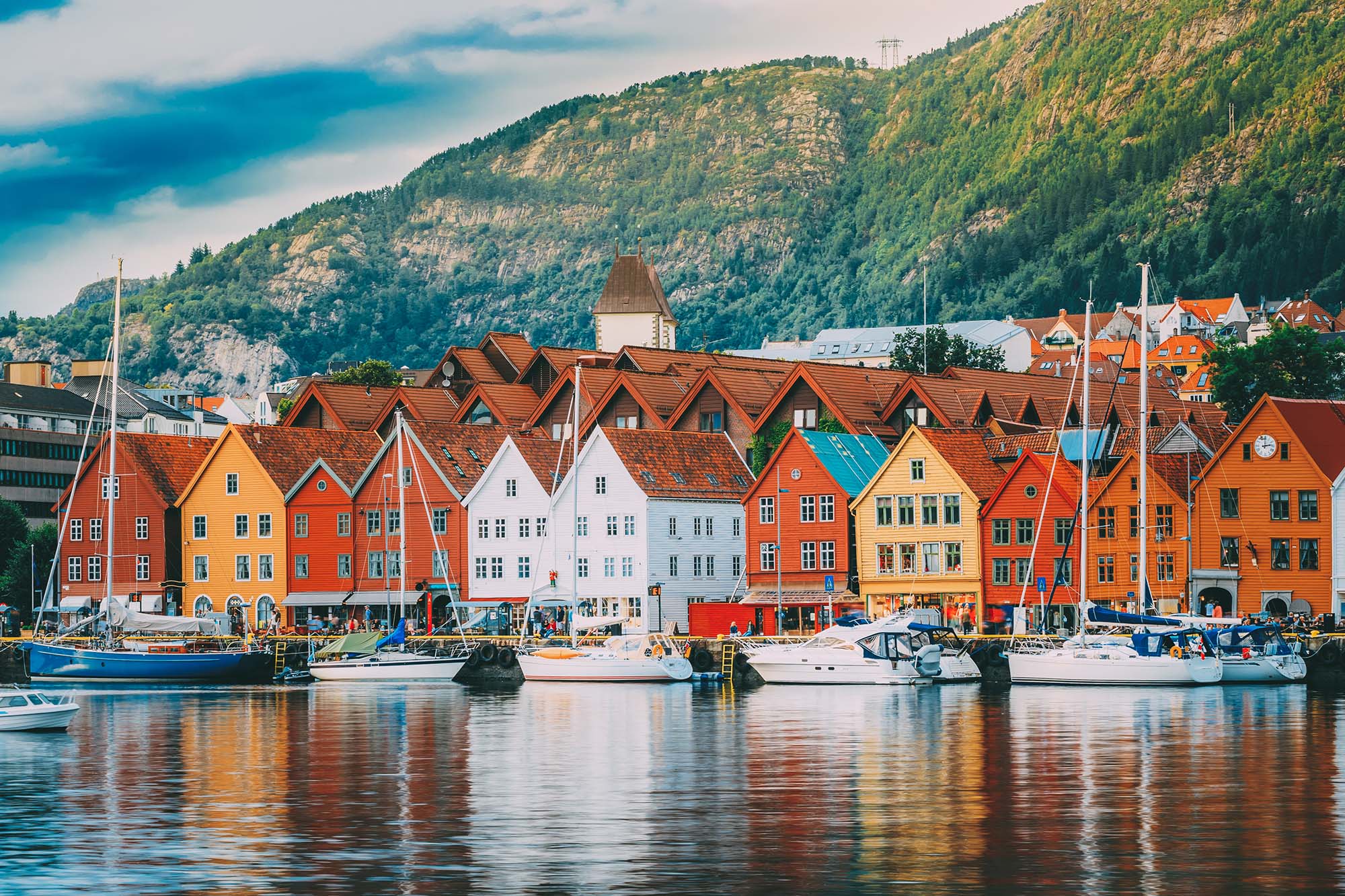 A group of boats floating on the water against a background of buildings