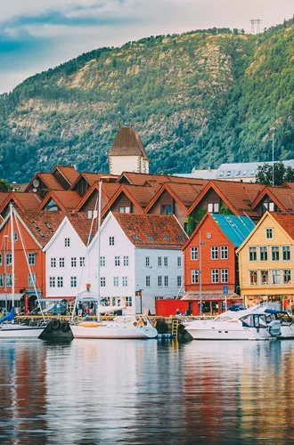 A group of boats floating on the water against a background of buildings