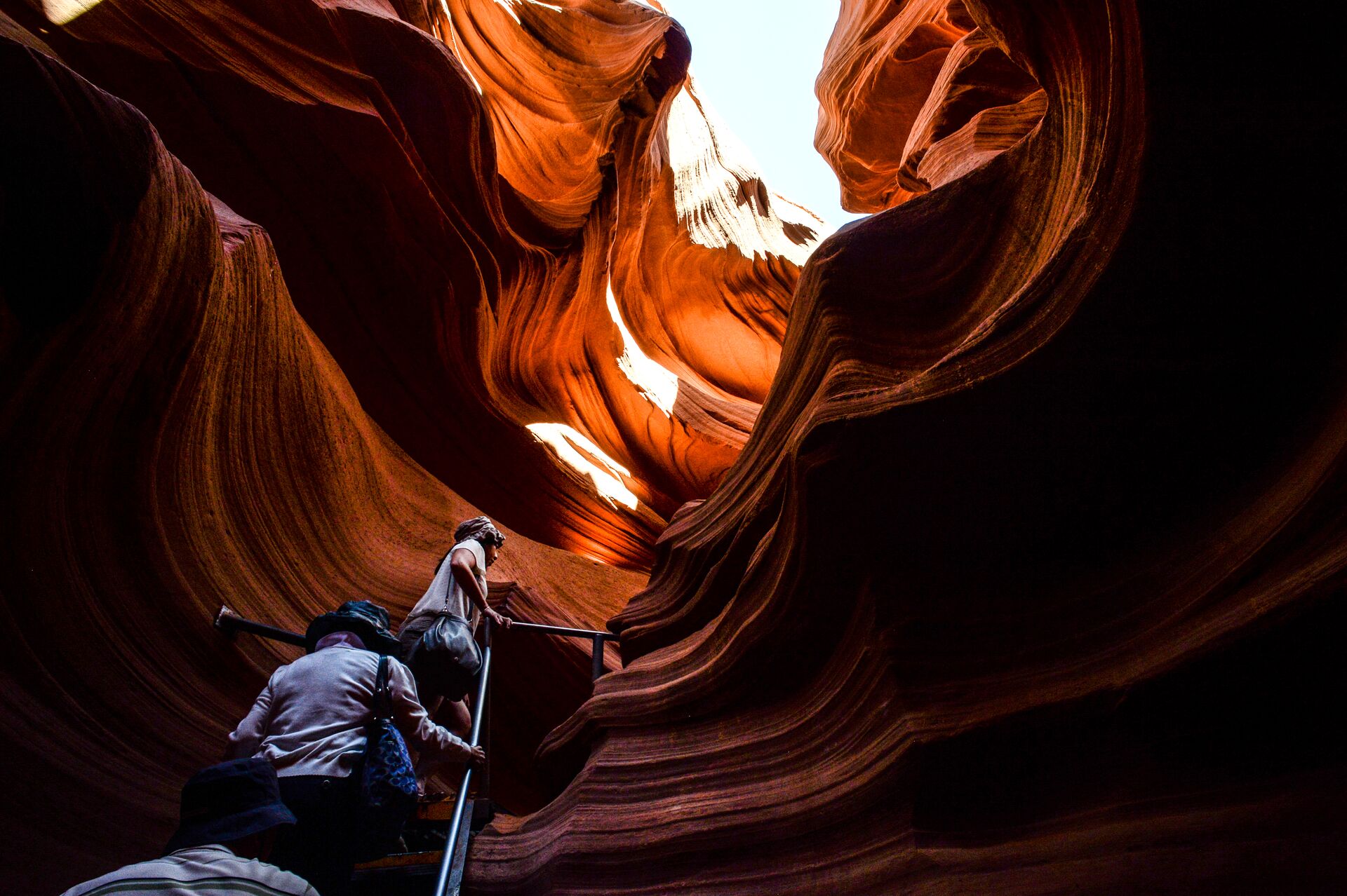 Tourists climbing stairs in a rock canyon