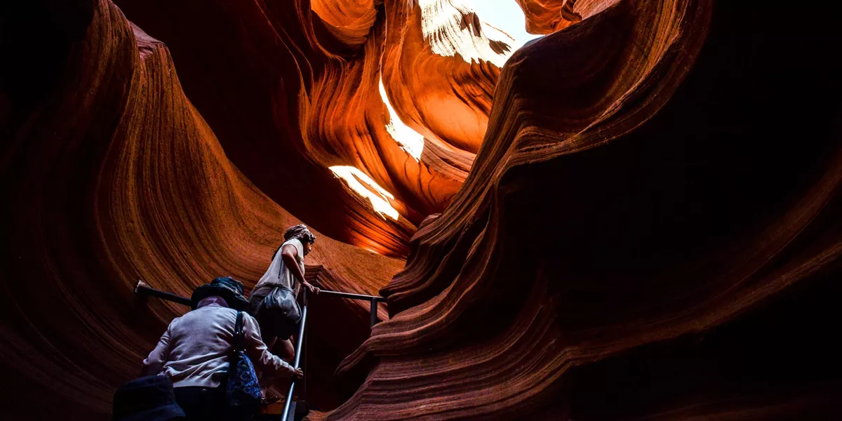 Tourists climbing stairs in a rock canyon