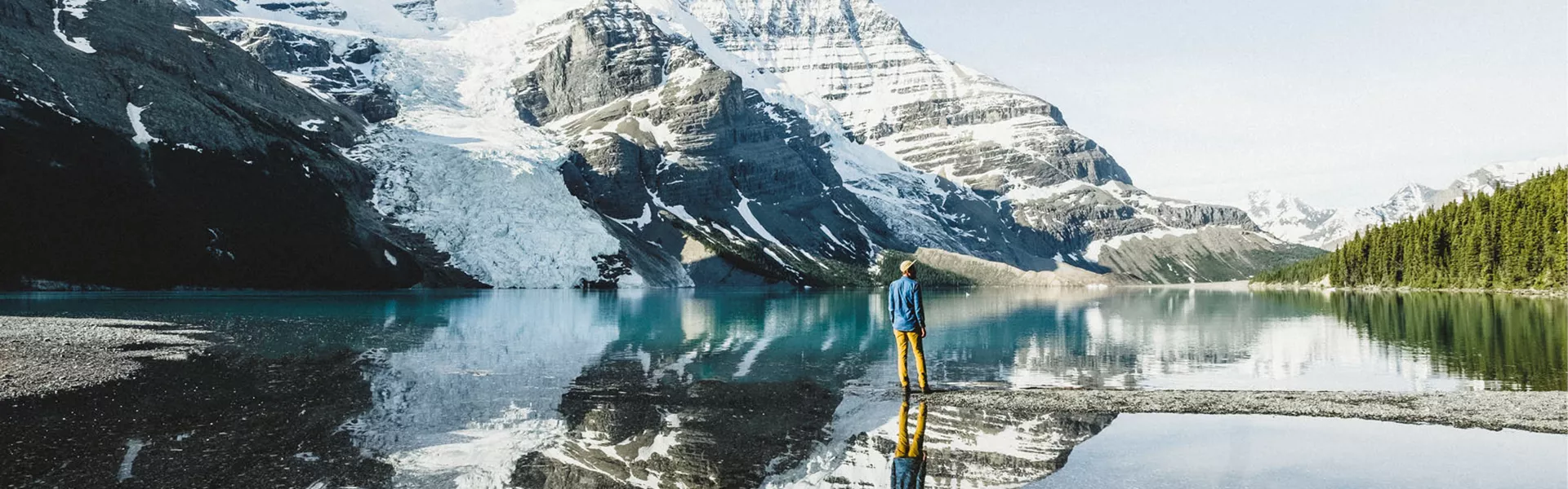 person standing in the middle of a lake in front of a mountain