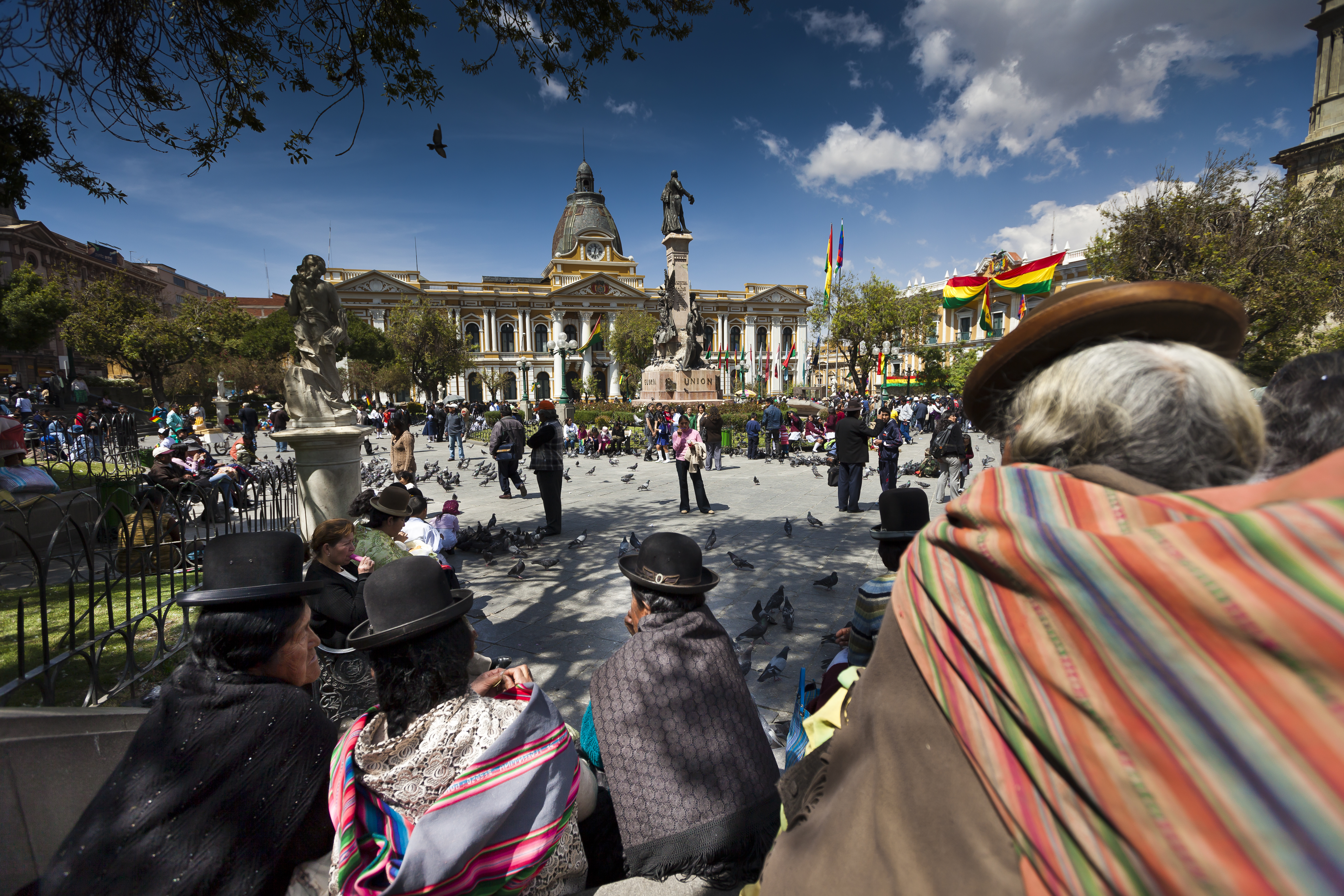 A group of people in costumes sitting on a bench in front of a building