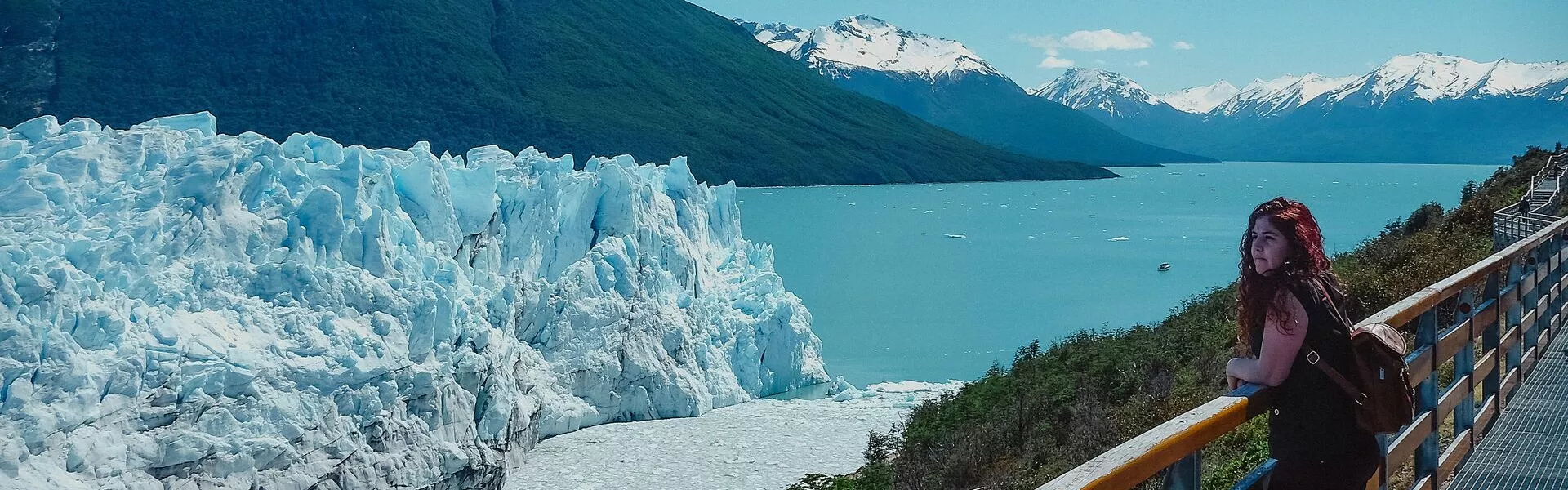 A Tourist Is Standing In Front Of The Glacier