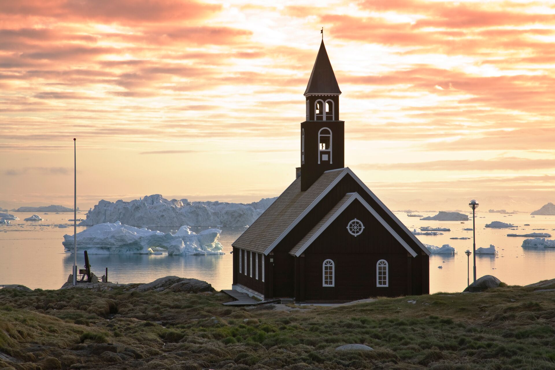 Church on the coast overlooking icebergs floating past