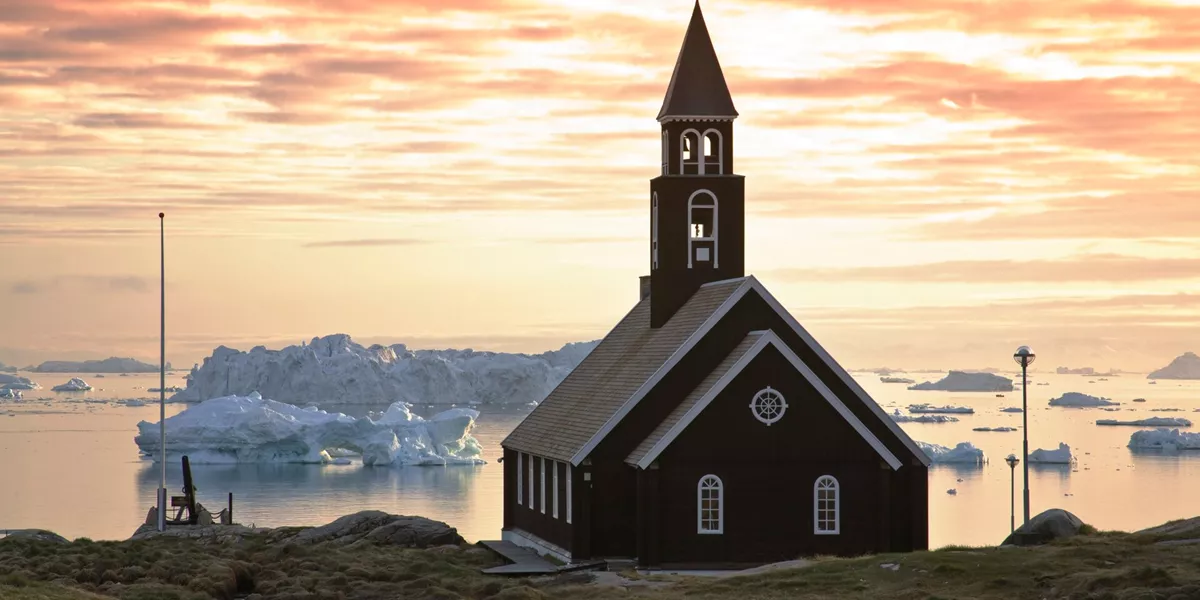 Church on the coast overlooking icebergs floating past