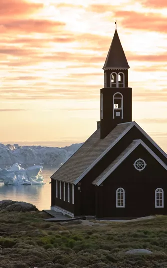 Church on the coast overlooking icebergs floating past