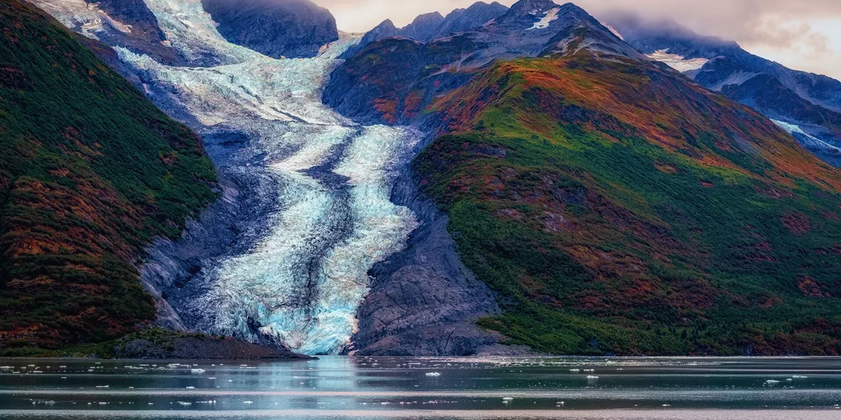 Glacier down a mountain leading into the sea