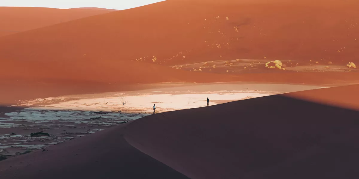 two travellers on large sand dunes