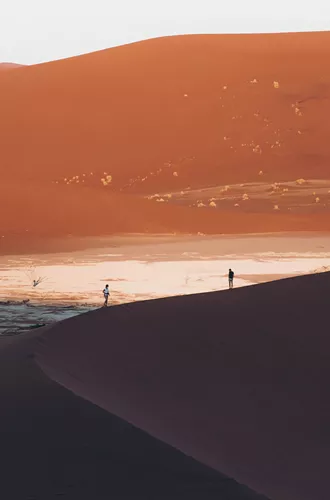 two travellers on large sand dunes