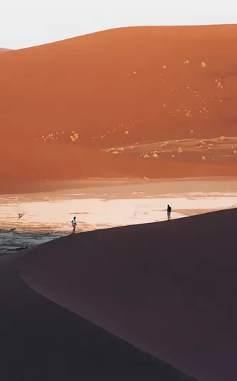 two travellers on large sand dunes