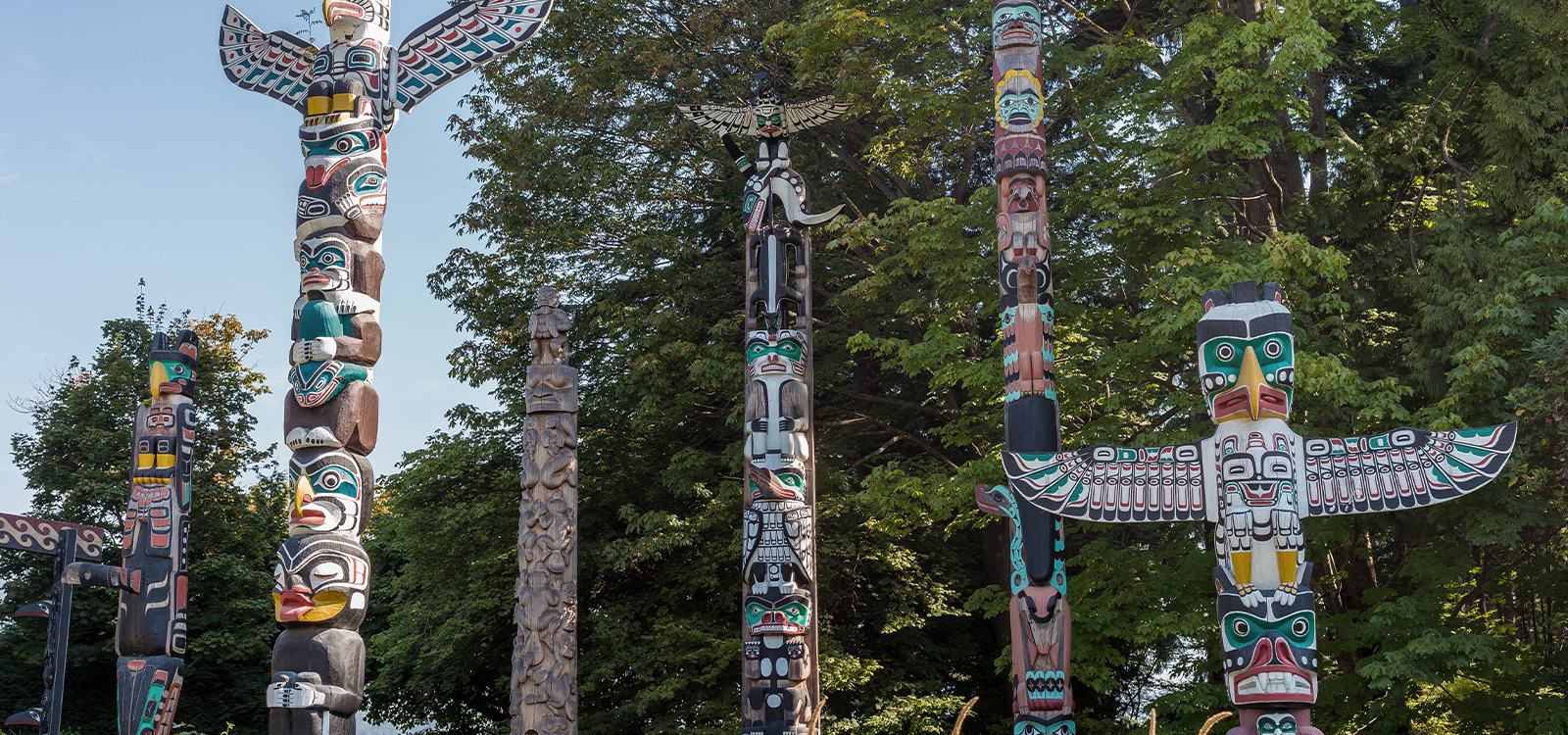 Colorful totem poles among green trees