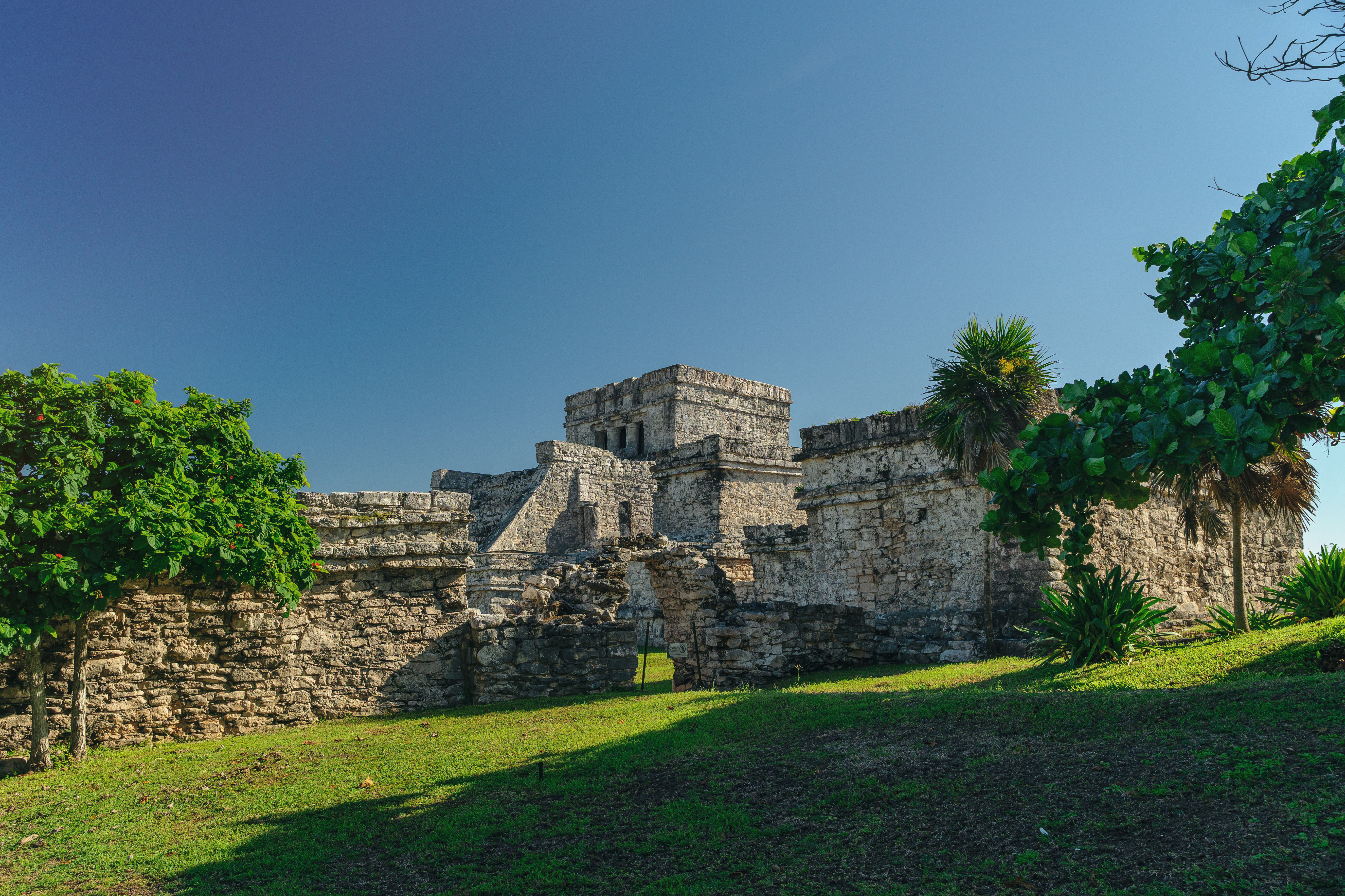 A large stone building sitting on top of a lush green field